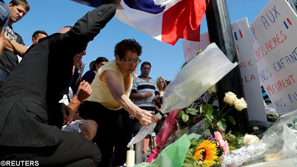 Pessoas colocando flores para as vítimas do atentado em Nice / Foto: Reuters