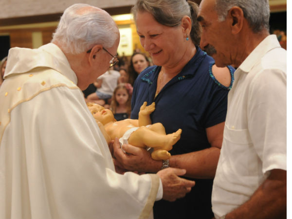 Monsenhor Jonas recebe imagem do Menino Jesus pelas de um casal. Foto: Micaelly Medeiros/cancaonova.com