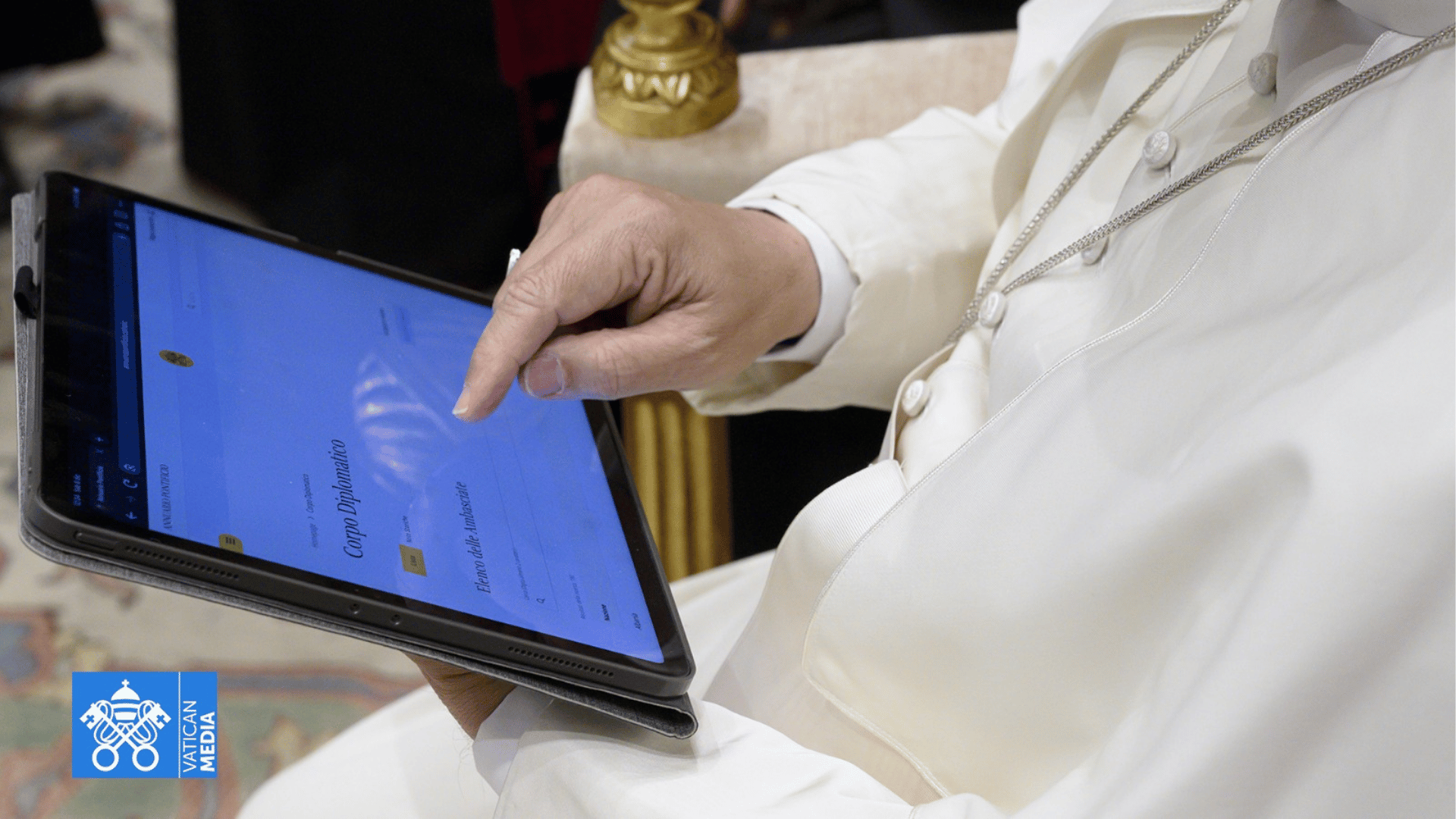 Papa usando um tablet enquanto navega por um documento digital durante um encontro no Vaticano