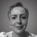 Imagem em preto e branco mostra mulher de cabelo curto, com brincos pequenos