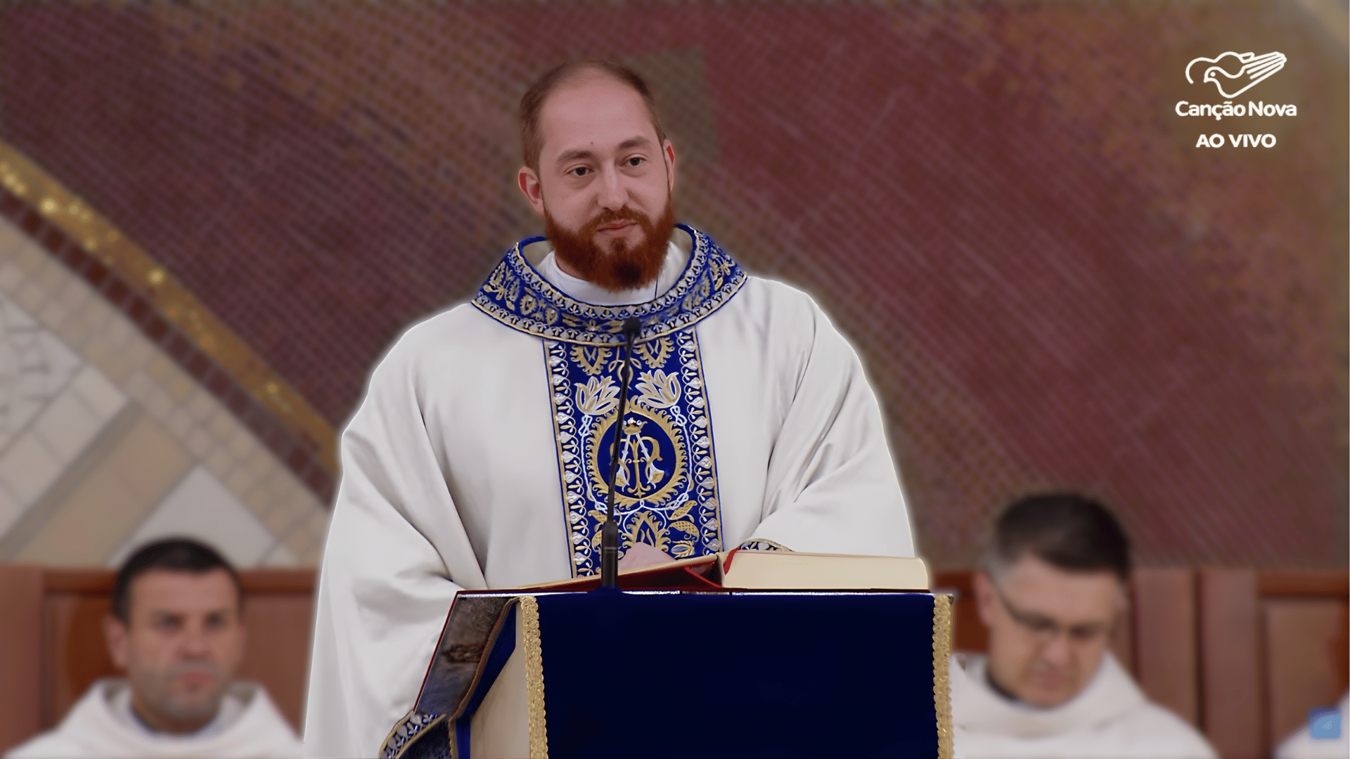 Sacerdote conduzindo a homilia durante a Missa, diante do ambão e com outros concelebrantes ao fundo