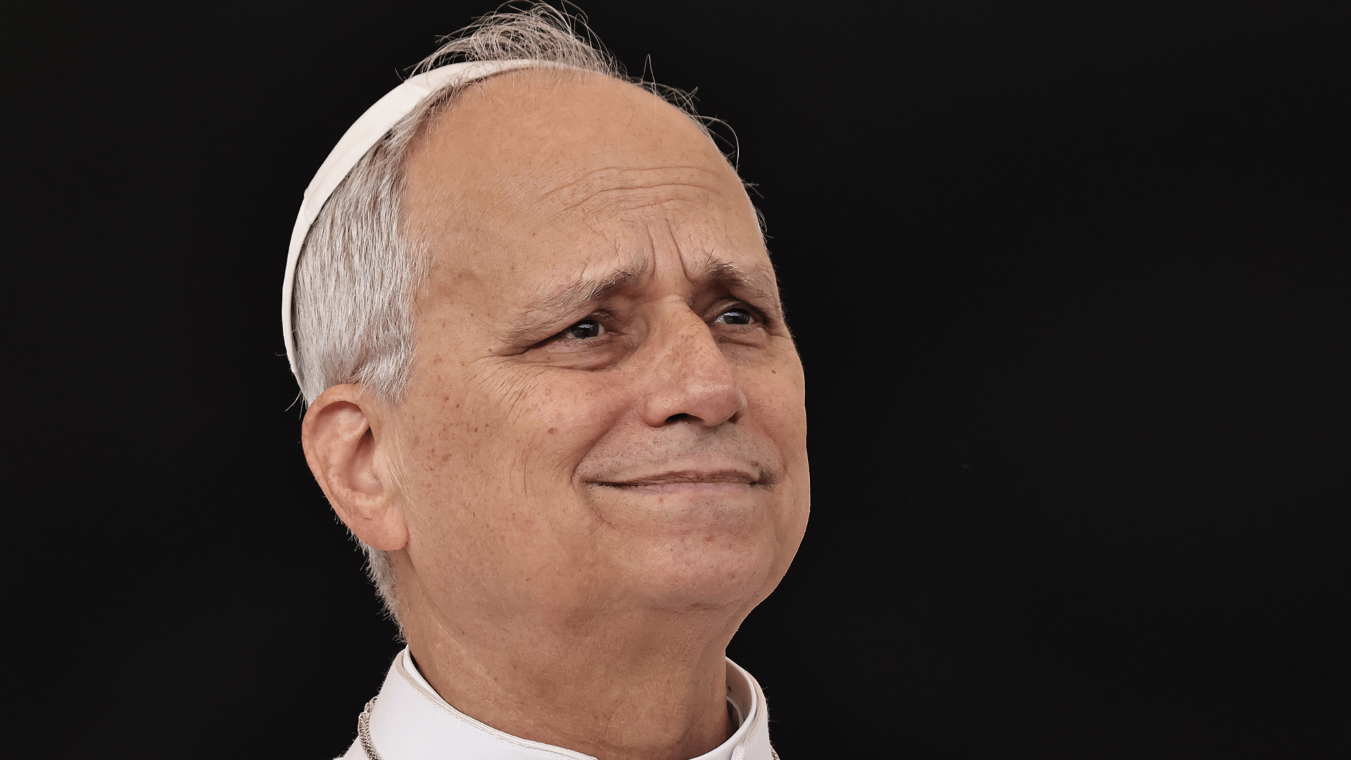 A imagem ilustra o Papa Leão XIV com suas habituais vestes pontifícias e uma expressão serena.