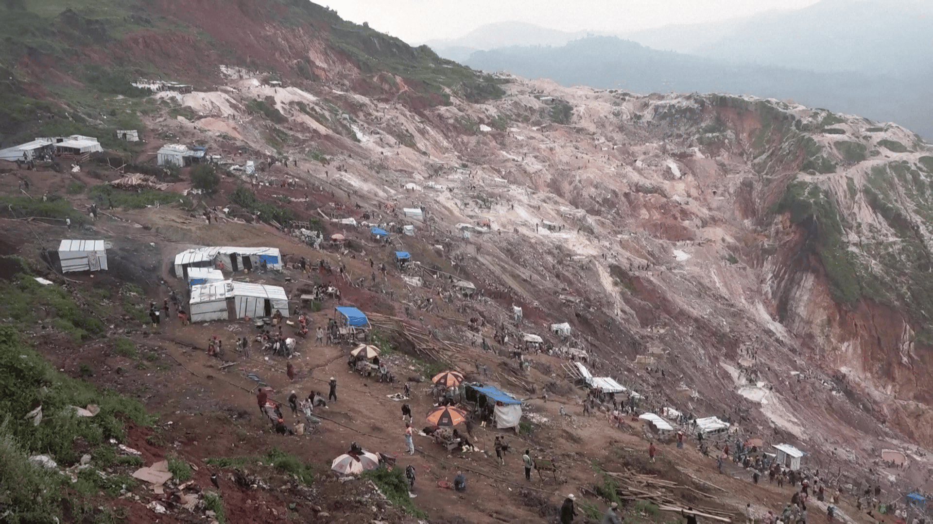 Busca e resgate de vítimas na jazida de Rubaya, na RD Congo A imagem ilustra um grupo de pessoas trabalhando no resgate de vítimas soterradas por um deslizamento.