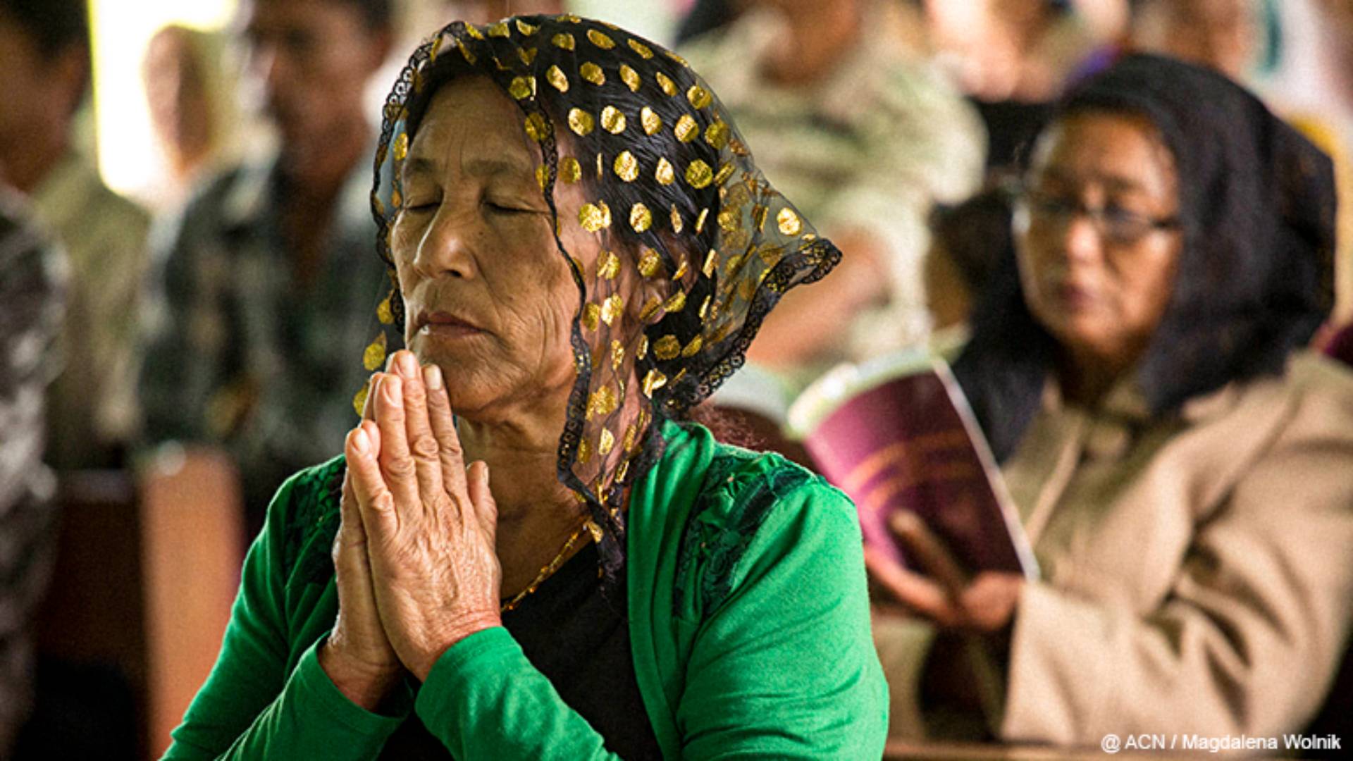 dia de oração pela paz em Mianmar Uma senhora ajoelhada rezando com as mãos postas