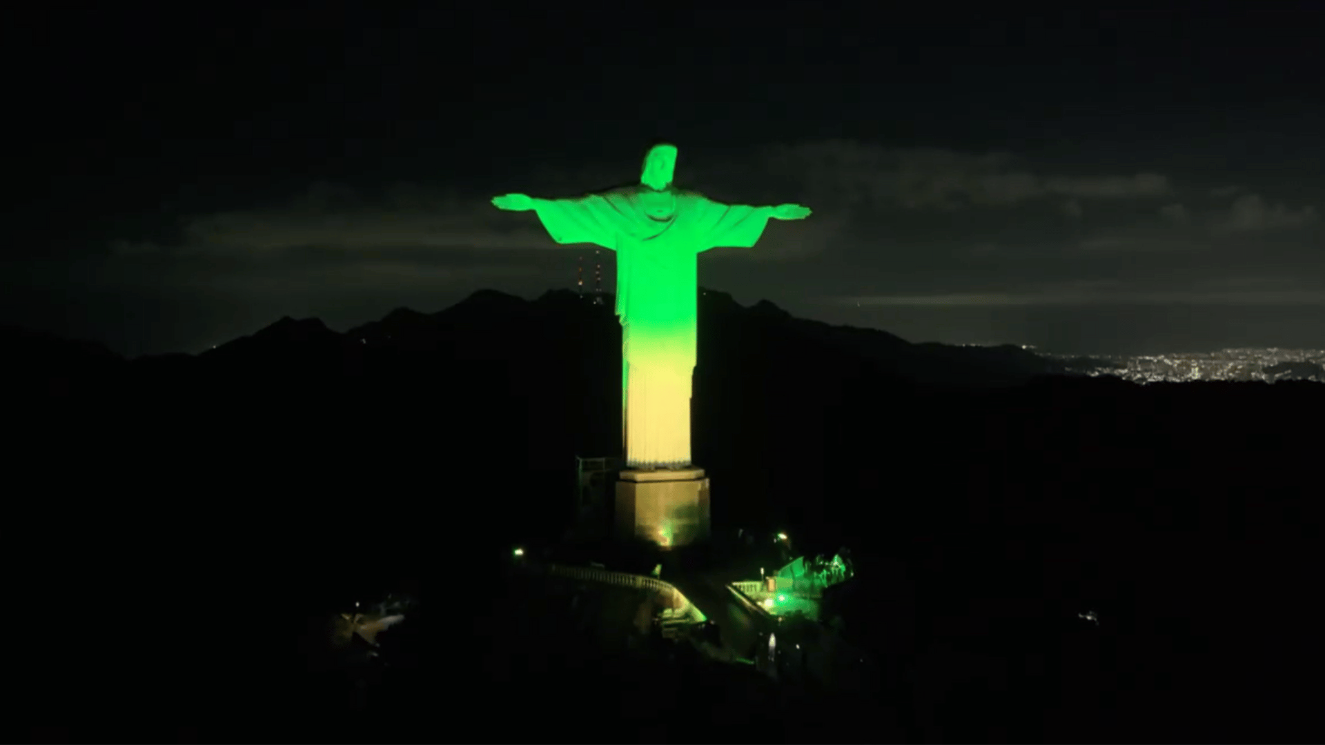 Iluminação especial no Cristo Redentor A imagem ilustra o monumento ao Cristo Redentor, no Rio de Janeiro, iluminado em um degradê verde (na parte superior) e amarelo (na parte inferior)