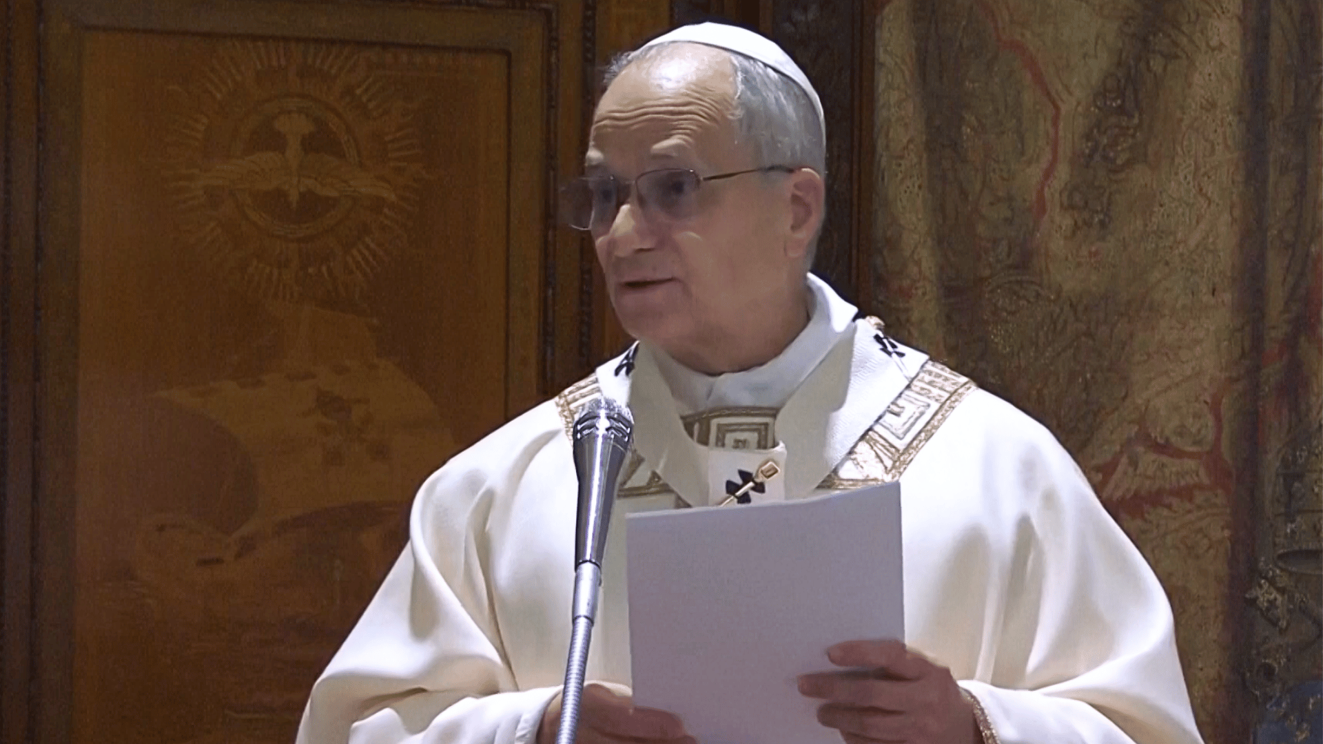 A imagem ilustra o Papa Leão XIV, liturgicamente paramentado, durante a homilia na Missa em que celebrou. O Pontífice segura algumas folhas de papel nas mãos e está diante de um microfone.