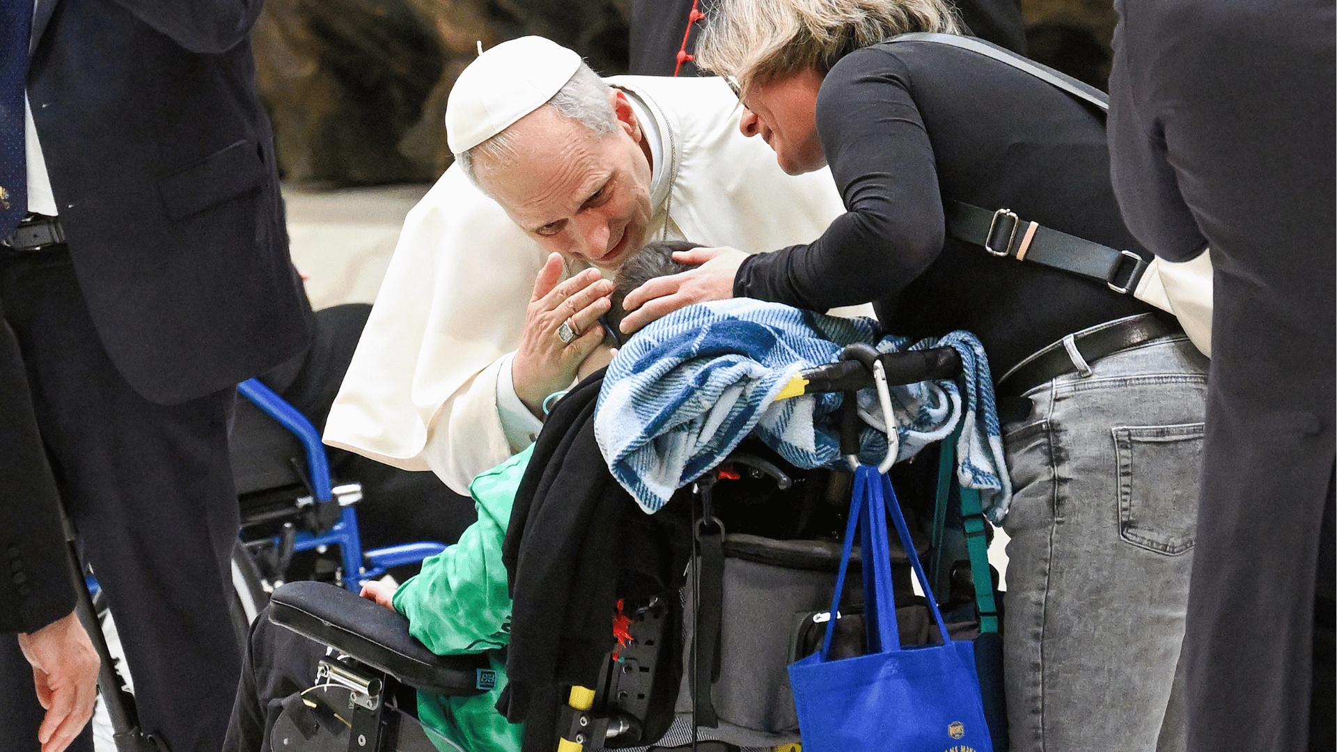 O Papa Leão XIV se reclina para acariciar o rosto de uma criança em cadeira de rodas