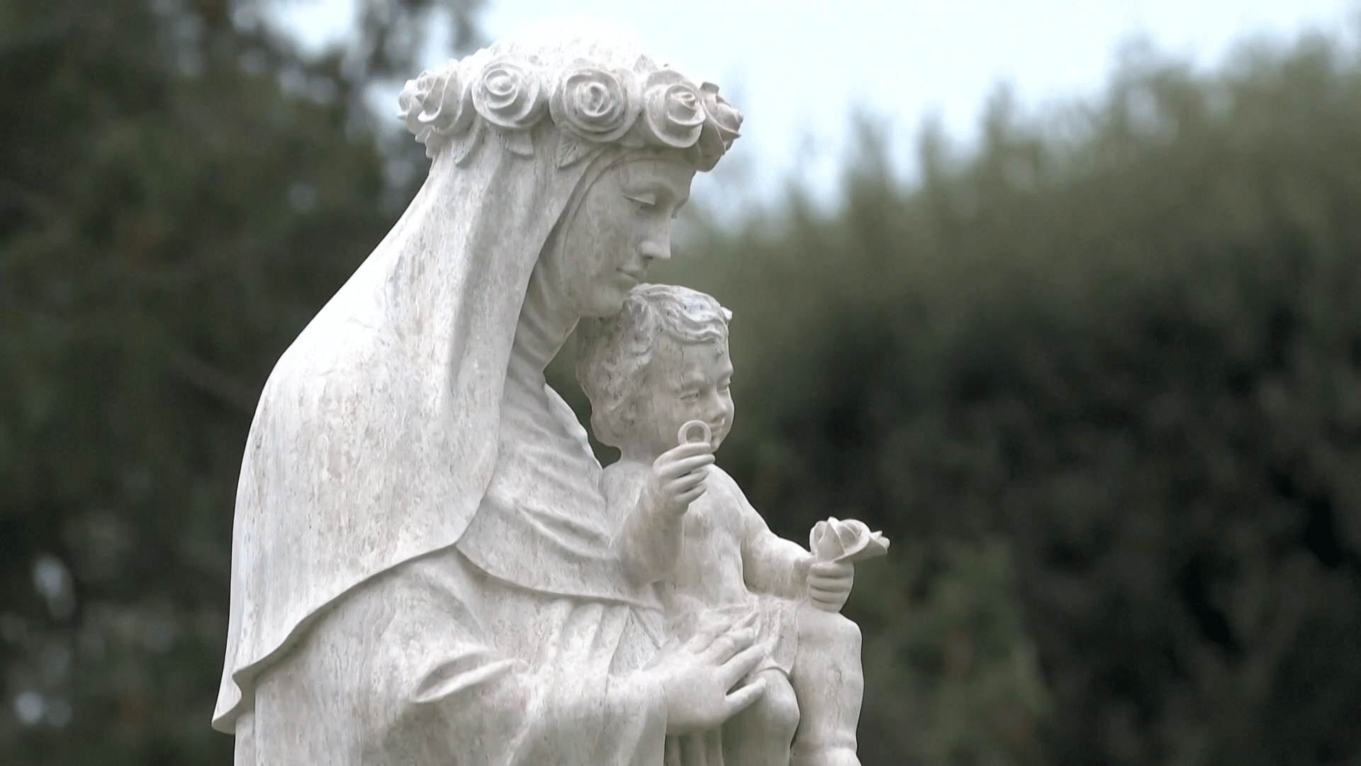 Imagem de Santa Rosa de Lima nos Jardins Vaticanos A foto retrata uma parte de uma imagem de Santa Rosa de Lima, com hábitos religiosos, uma coroa de rosas na cabeça e o Menino Jesus nos braços.