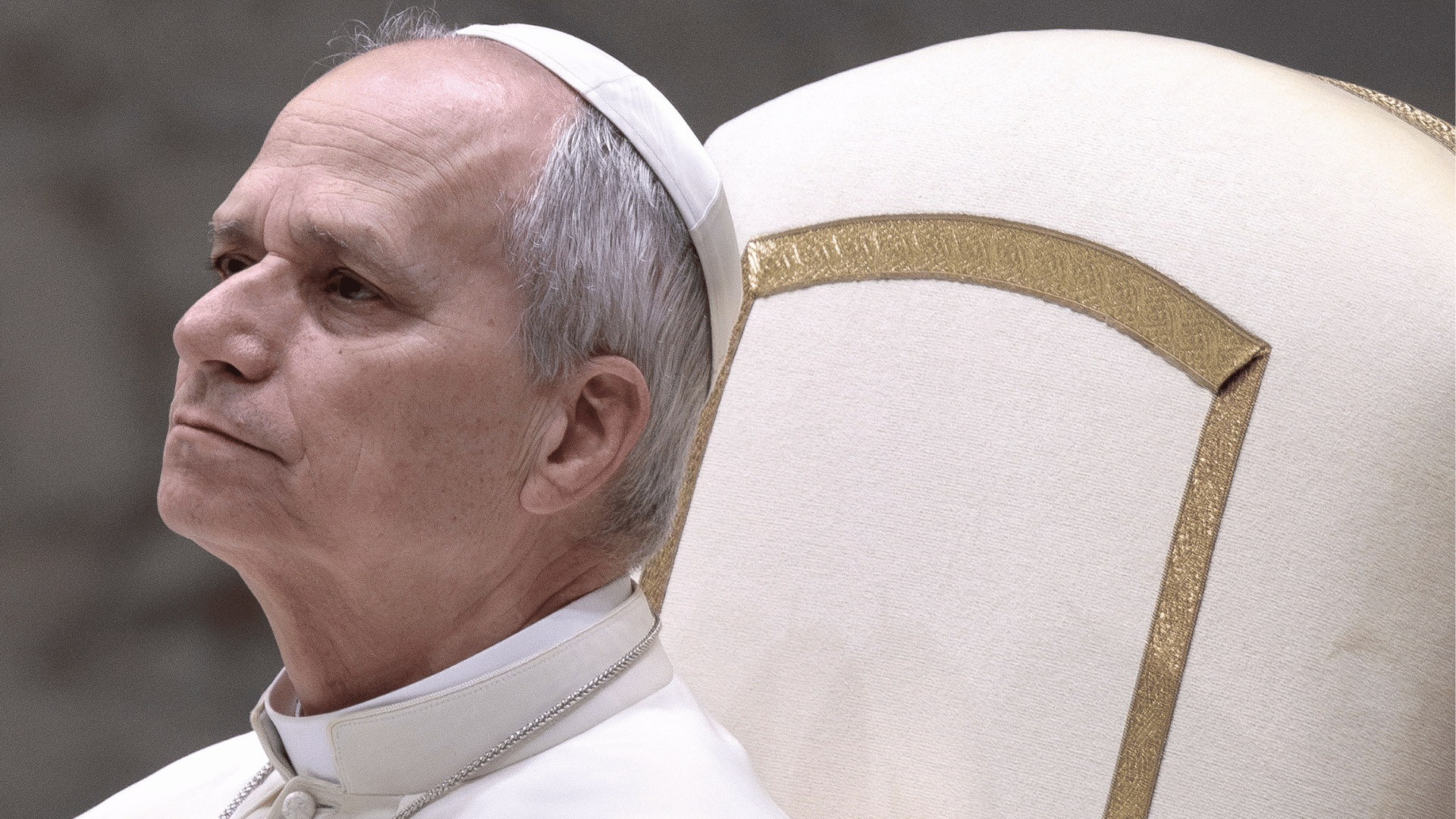 Papa Leão XIV sentado em cadeira branca, usando a tradicional veste branca e solidéu, com expressão serena durante Audiência Geral na Sala Paulo VI, no Vaticano