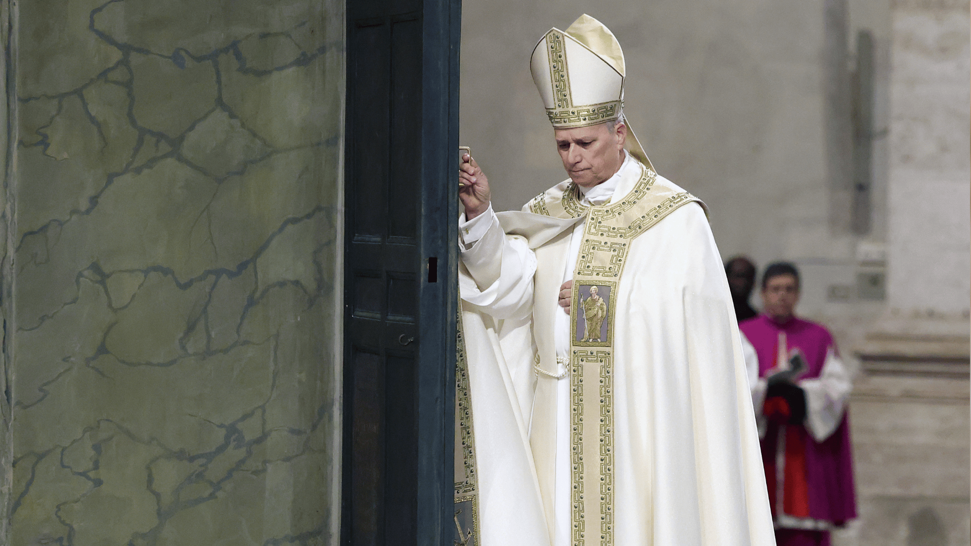 Papa vestido com paramentos litúrgicos brancos fecha a Porta Santa da Basílica de São Pedro durante celebração solene