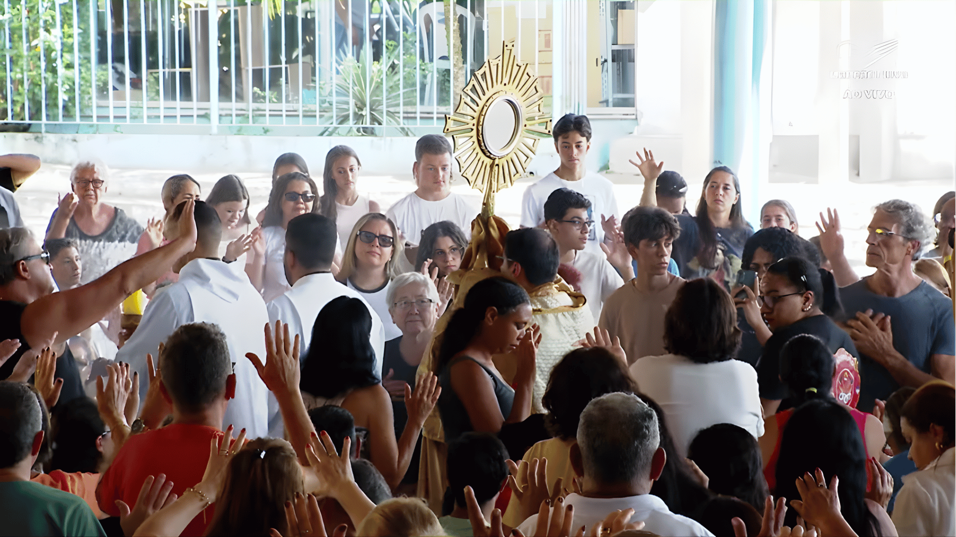 Um sacerdote conduz o Santíssimo Sacramento em meio a uma multidão de fiéis