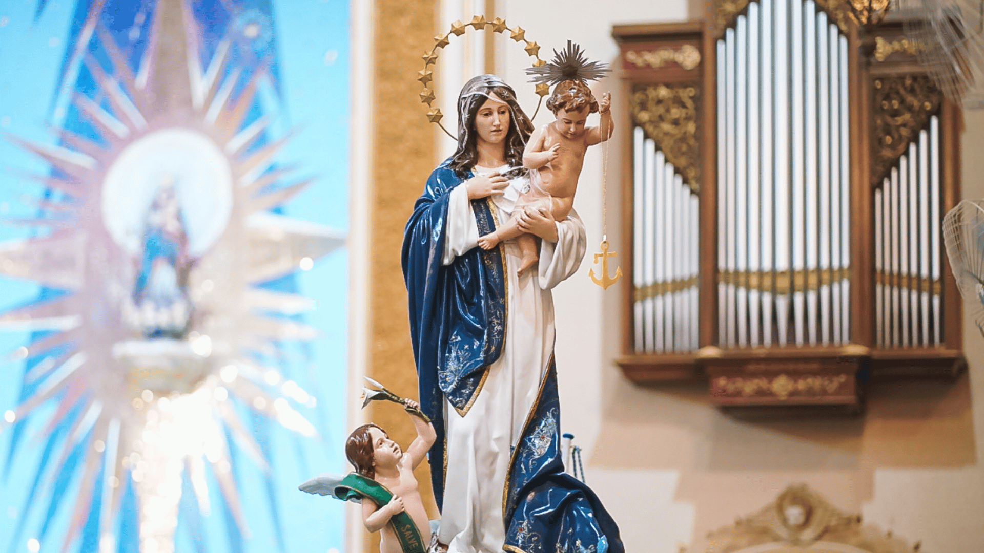 Nossa Senhora dos Navegantes A fotografia retrata um aimagem de Nossa Senhora dos Navegantes, vestida de branco e azul e com o Menino jesus nos braços, que por sua vez carrega uma âncora.