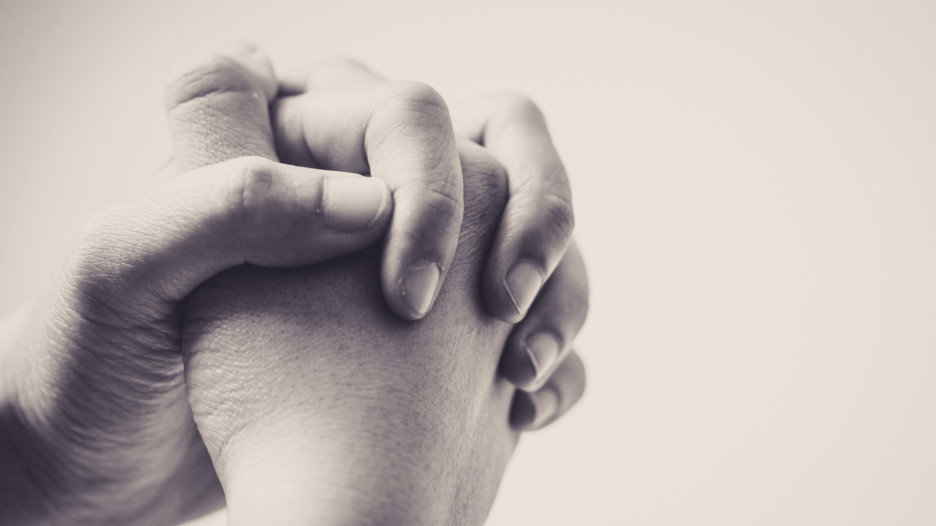 A imagem ilustra duas mãos unidas, em gesto de oração