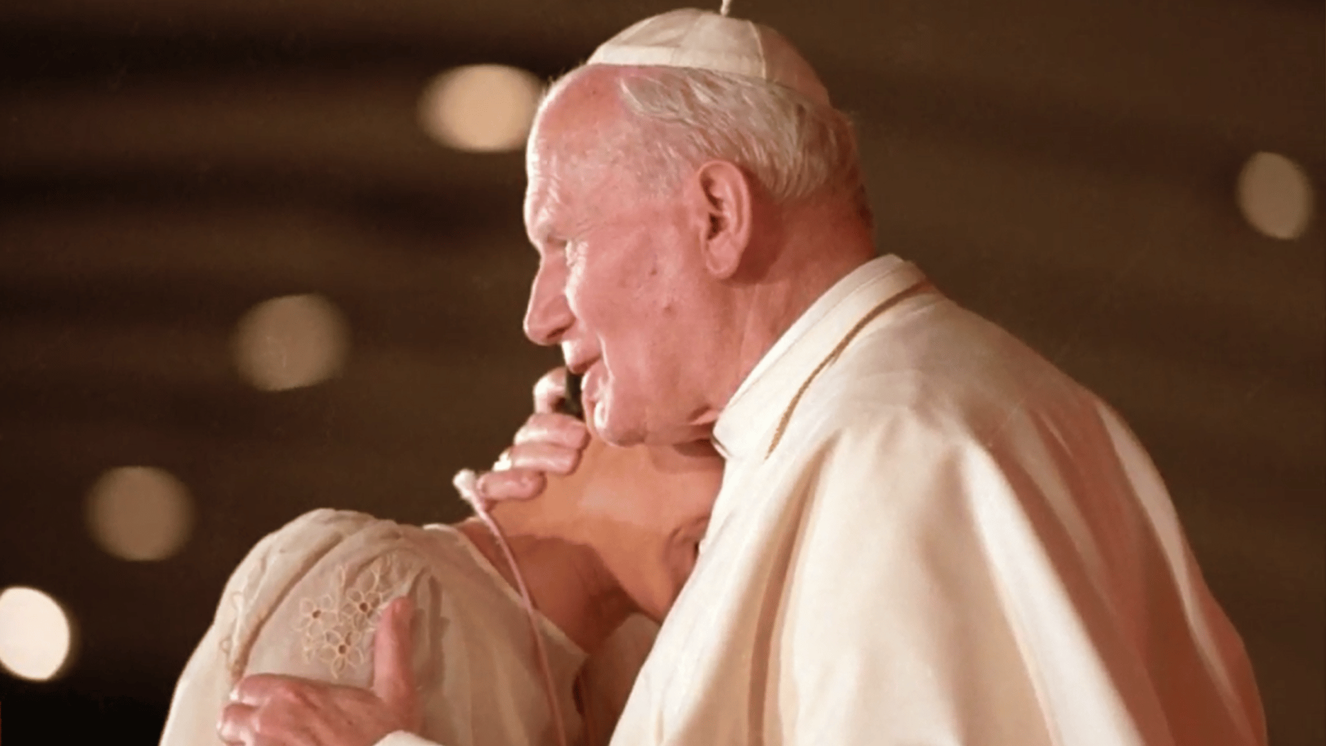 A imagem ilustra o abraço do Papa João Paulo II a uma jovem na JMJ Manila 1995.