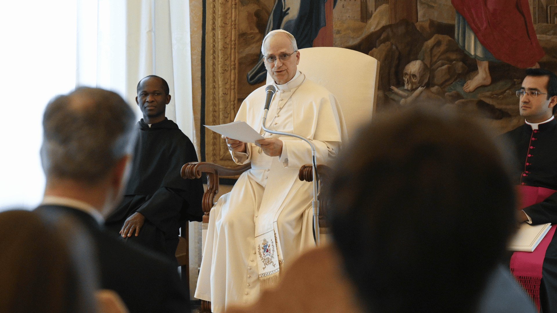 Papa Leão XIV em audiência com a Pontifícia Comissão para a Tutela dos Menores A imagem ilustra o Papa Leão XIV, com suas habituais vestes pontifícias, sentado e falando diante de um microfone durante uma audiência