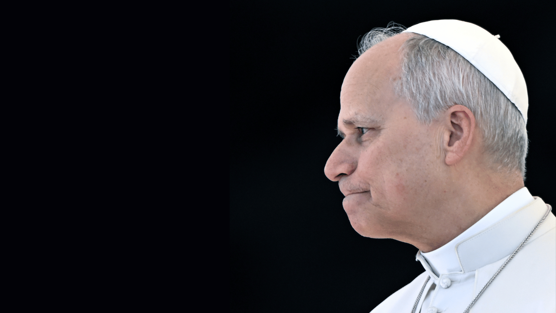 A imagem ilustra o Papa Leão XIV, com suas habituais vestes pontifícias, de perfil, em contraste com um fundo escuro.