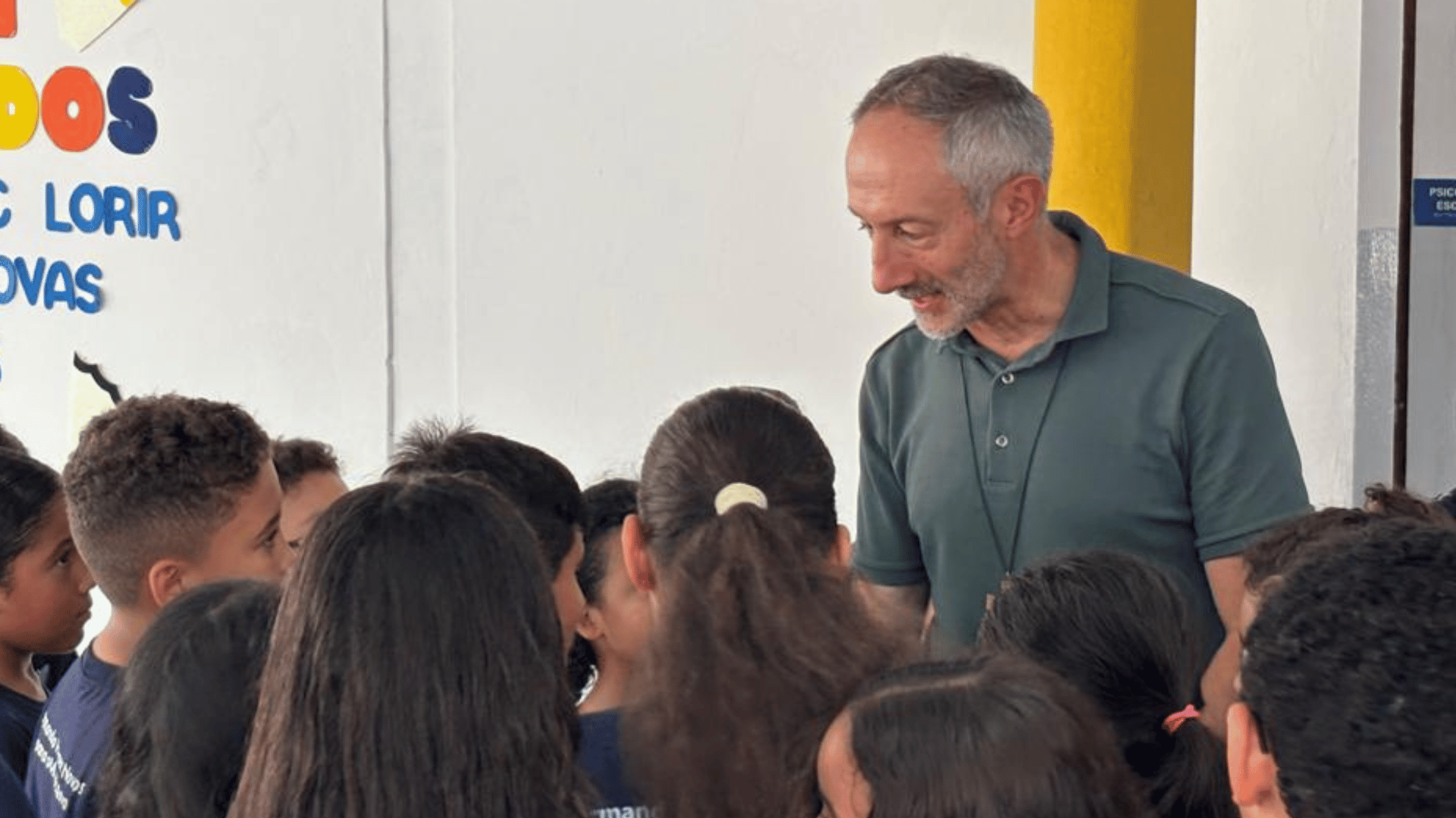 A imagem ilustra um padre cercado por crianças.