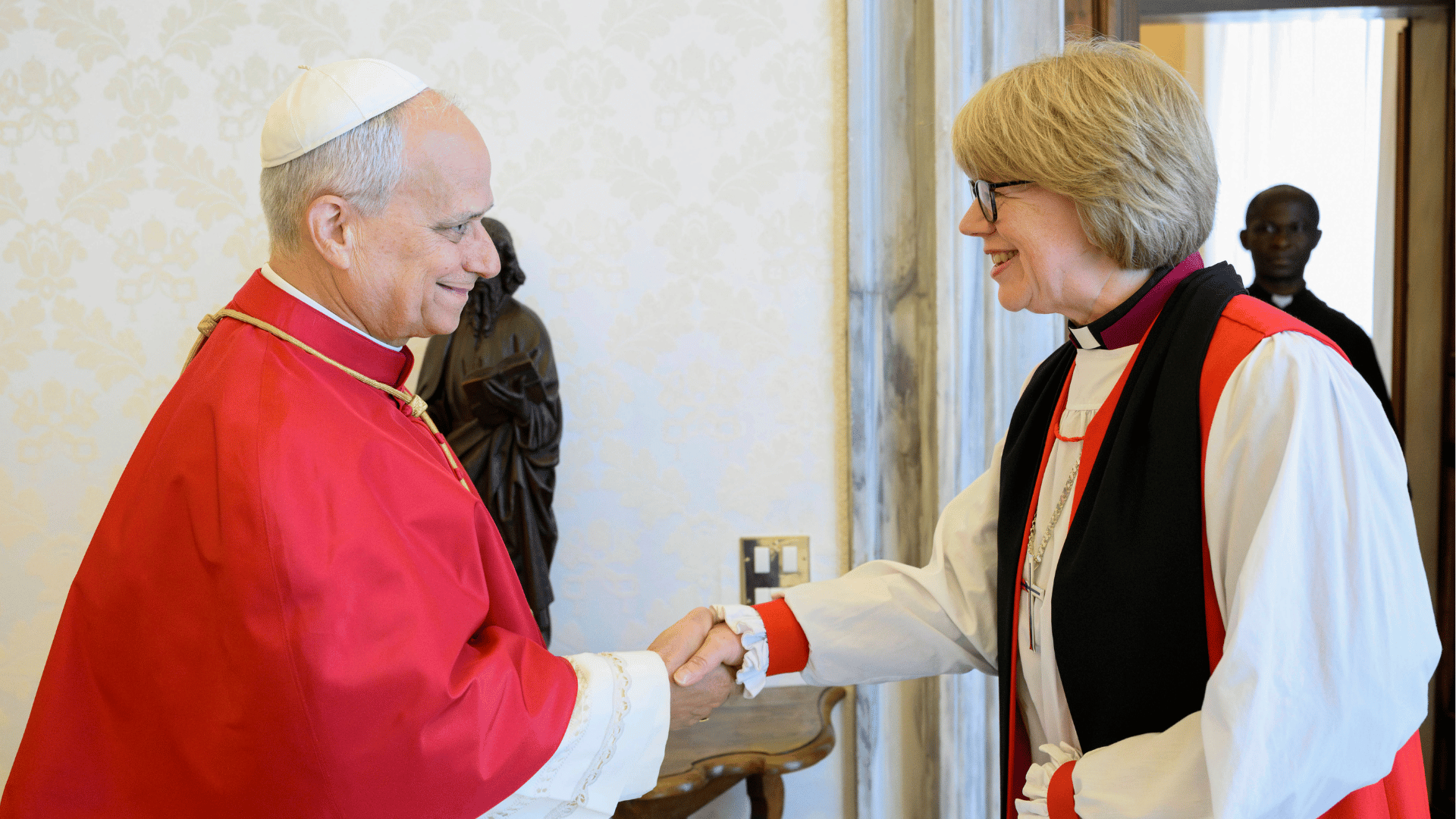 A imagem ilustra o Papa Leão XIV, vestido com mozeta, cumprimentando a arcebispa da Cantuária, Sarah Mullally