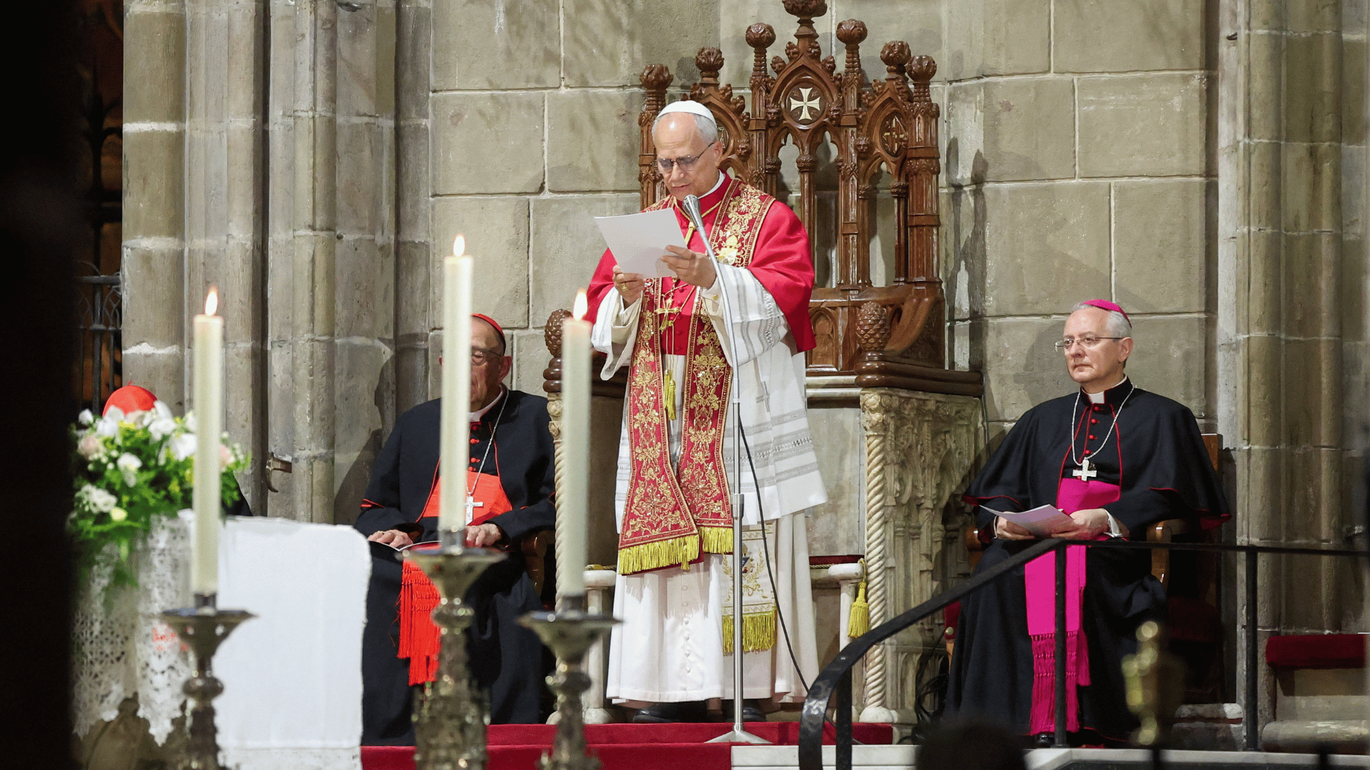 Papa Leão XIV rezou a Hora Média na Catedral da Santa Cruz e Santa Eulália, em Barcelona A imagem ilustra o Papa Leão XIV vestido com suas habituais vestes pontifícias brancas, mozeta e estola, em pé, lendo uma folha de papel que segura em suas mãos.