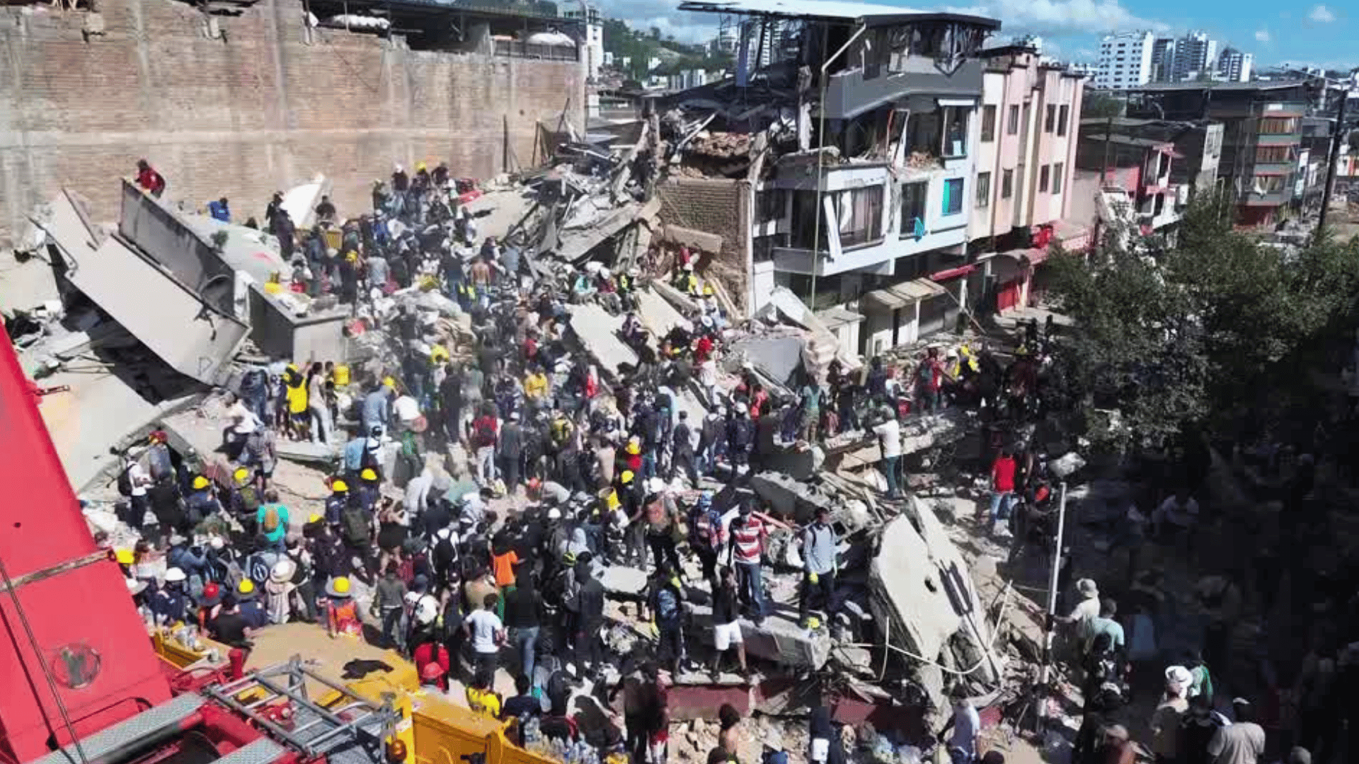 Socorristas e civis ajudam nas buscas diante de escombros de prédios na Colômbia.