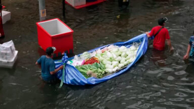 Ruas alagadas de Bangkok viram mercado flutuante
