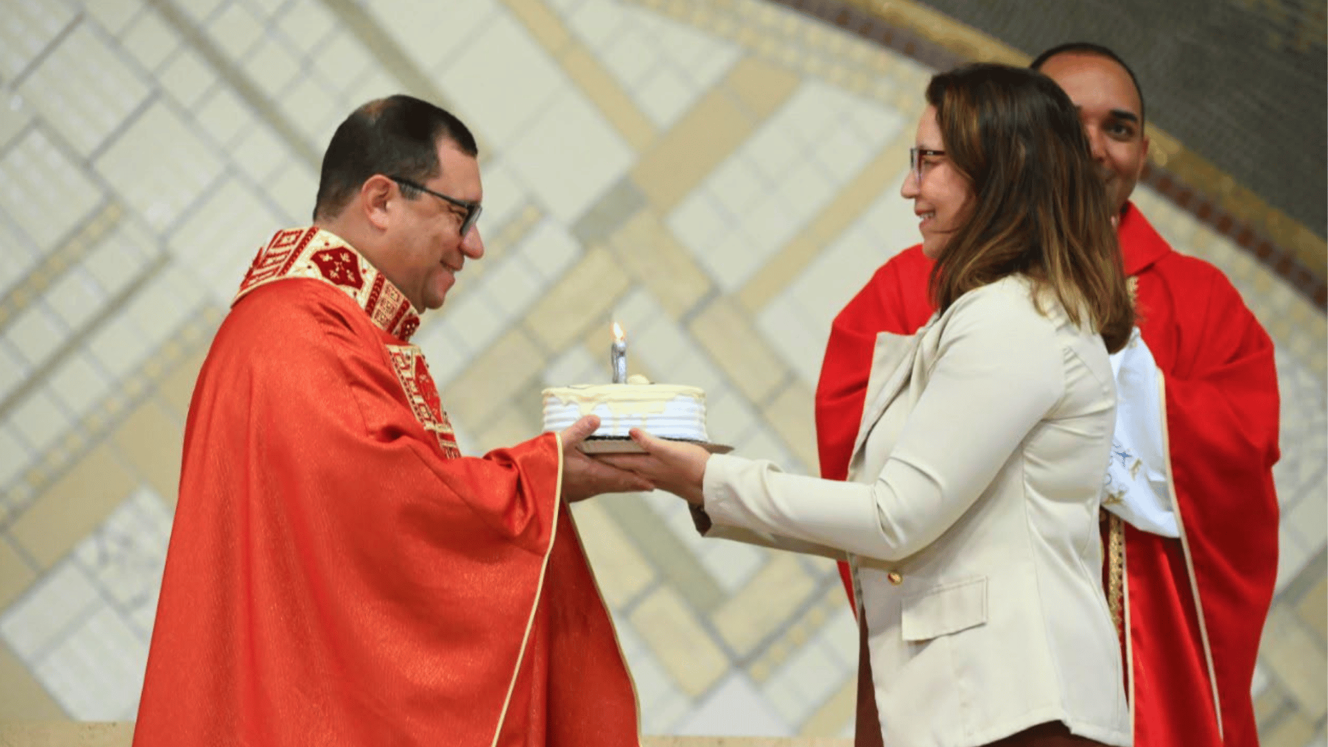 Padre Wagner Ferreira recebe bolo comemorativo das mãos de Deusirene Alves, diretora executiva da Fundação João Paulo II, ao final da Santa Missa.