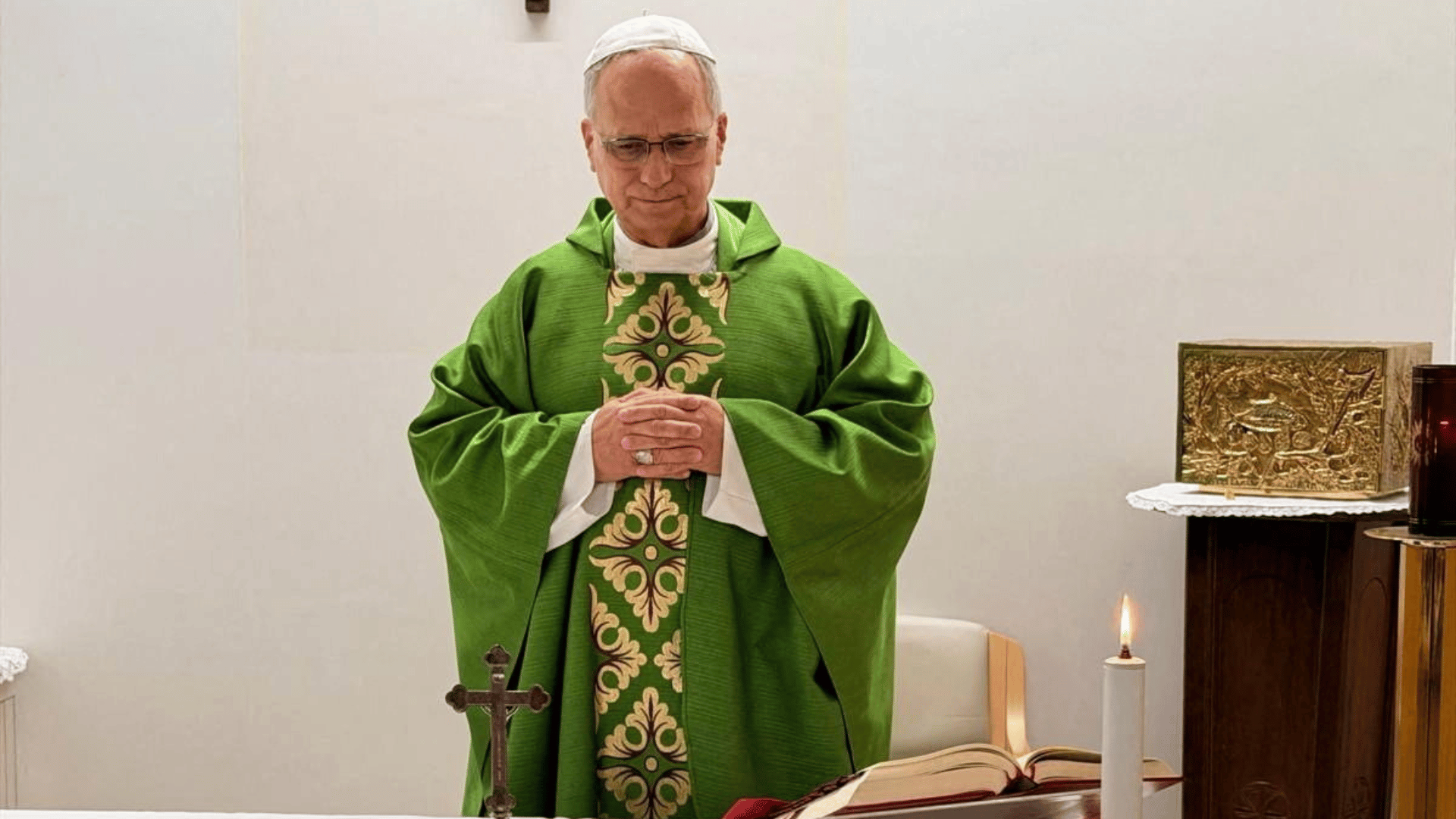 A foto mostra o Papa Leão XIV em pé vestindo paramento litúrgico verde. Ele está com as mãos cruzadas em posição de oração. 