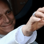 A imagem mostra o Papa Leão XIV dentro de um carro acenando pela janela