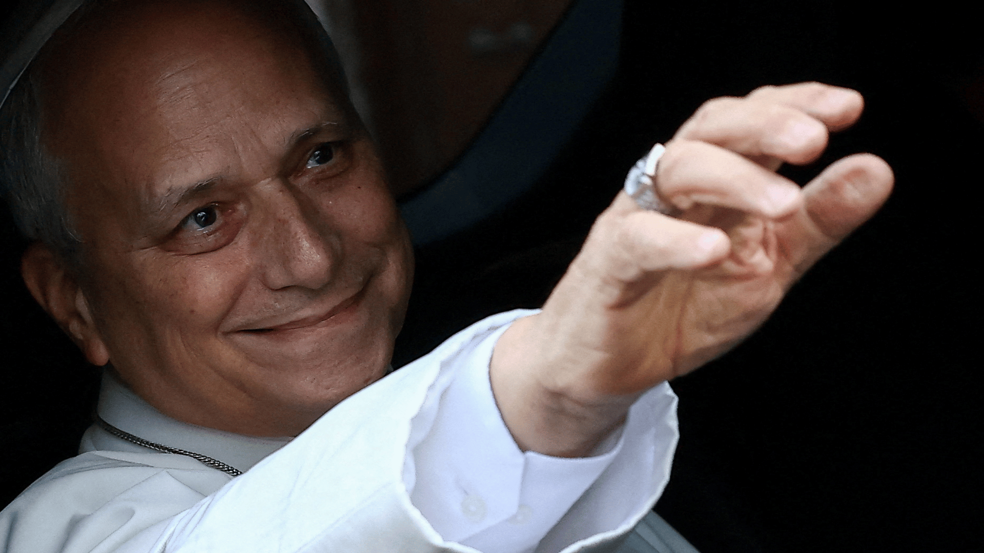 A imagem mostra o Papa Leão XIV dentro de um carro acenando pela janela