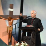 Dom Falcão falando em um púlpito sinalizando, ao fundo uma imagem de Jesus crucificado. Tema: "Porei inimizade entre ti e a mulher"