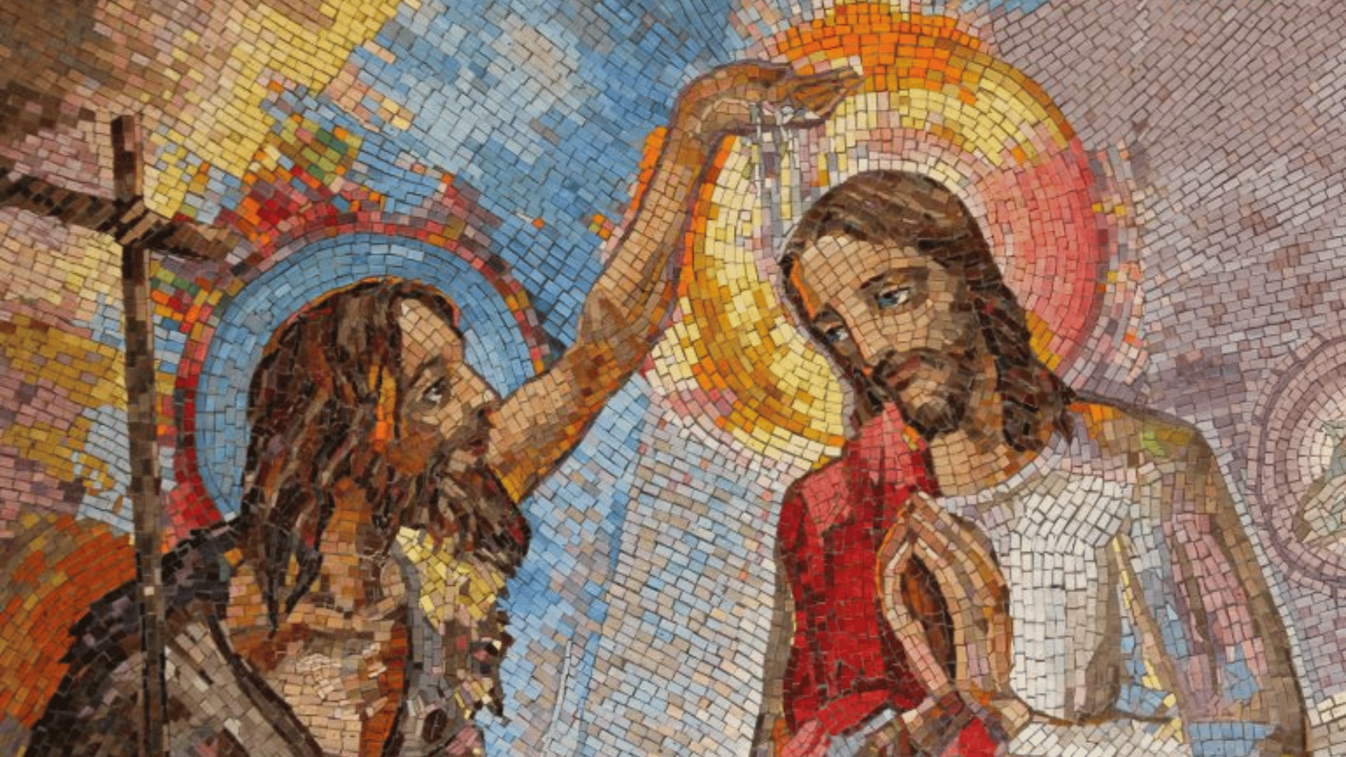 São João Batista Um mosaico colorido e detalhado retrata o Batismo de Cristo por João Batista. João, à esquerda com uma barba desalinhada, derrama água sobre a cabeça inclinada de Jesus. Jesus, à direita com as mãos postas em oração e uma auréola dourada brilhante, recebe o batismo. O fundo apresenta um padrão de mosaico radiante em tons de azul, dourado e laranja.