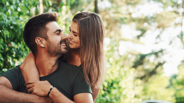  Companheira : Casal sorridente em momento de carinho ao ar livre.