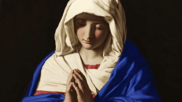 Pintura da Virgem Maria em oração, com véu branco e manto azul sobre um fundo escuro.