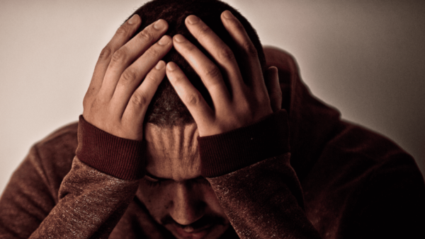 um homem com as mãoss na cabeça com teor de preocupaçãpo