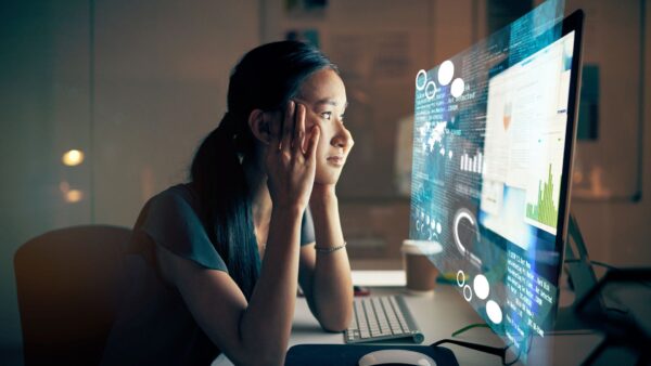 Mulher diante de uma tela de computador, representando os efeitos do uso excessivo da tecnologia sobre a atenção e a vida cotidiana.