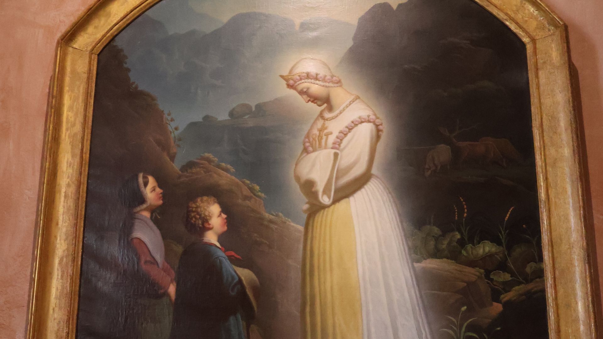 A imagem retrata a aparição de Nossa Senhora de La Salette aos dois pastorzinhos, Maximin Giraud e Mélanie Calvat, na França, localizada no interior da Basílica de Nossa Senhora de la Salette na França.
