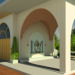 A foto mostra uma construção com estilo arquitetônico elegante e religioso. O espaço possui grandes arcos revestidos com textura clara e detalhes internos em tom amadeirado. No centro, há um pequeno altar externo em formato de nicho, onde se encontra uma imagem sacra emoldurada por detalhes decorativos. O local transmite serenidade e acolhimento, cercado por vegetação verde e um caminho pavimentado em tons terrosos. Plantas ornamentais em vasos alinhados ao longo da fachada completam o ambiente, dando um toque de harmonia e beleza.