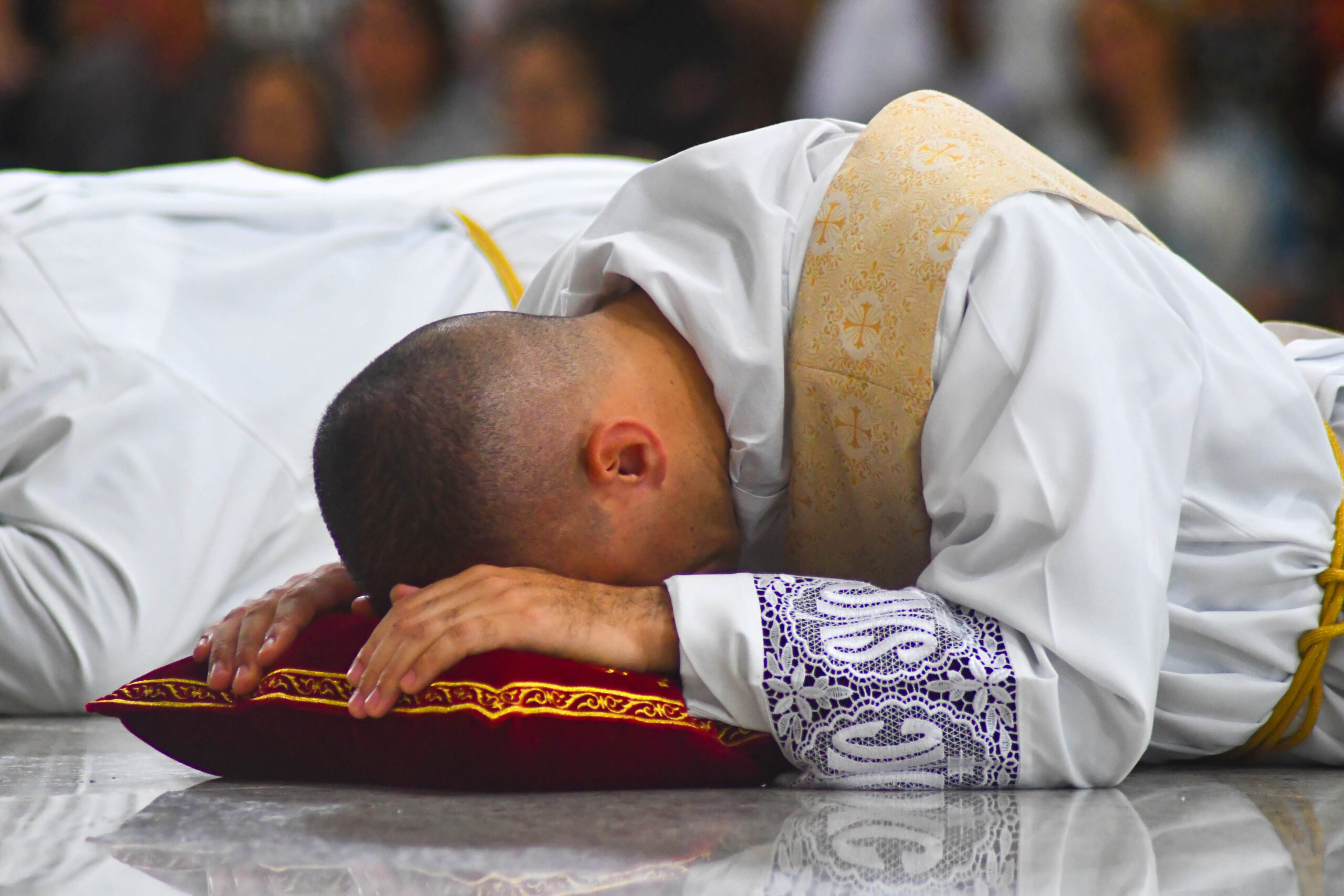 eleitos se prostram no rito de ordenação no Santuário do Pai das Misericórdias durante a celebração presbiteral dos novos padres da Comunidade Canção Nova 