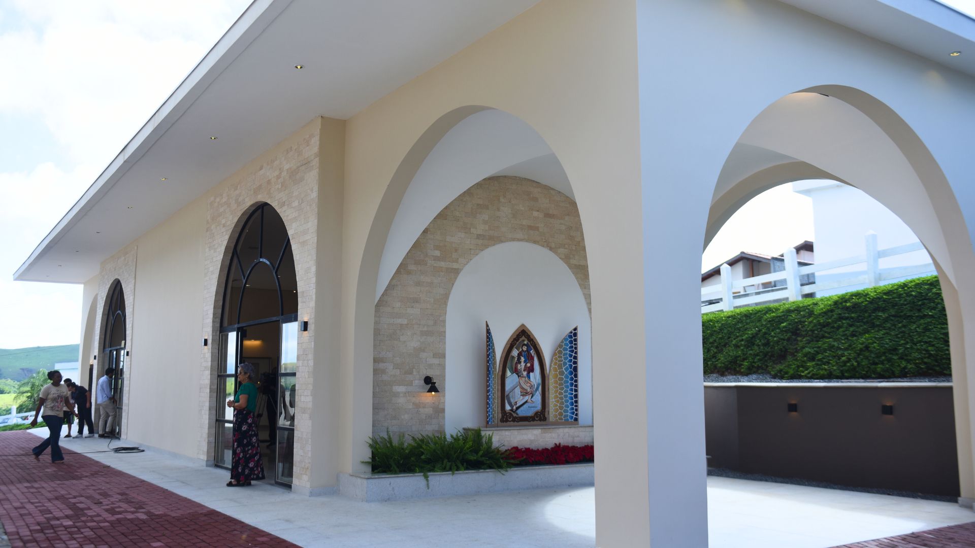 fachada da Nova Sala das Graças com mosaico a frente e pessoas visitando