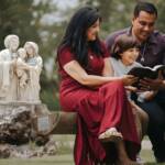 Fevereiro mês da família. Imagem de uma família com o filho, sentando e lendo a bíblia juntos. Atrás fundo verde com imagem da sagrada família.